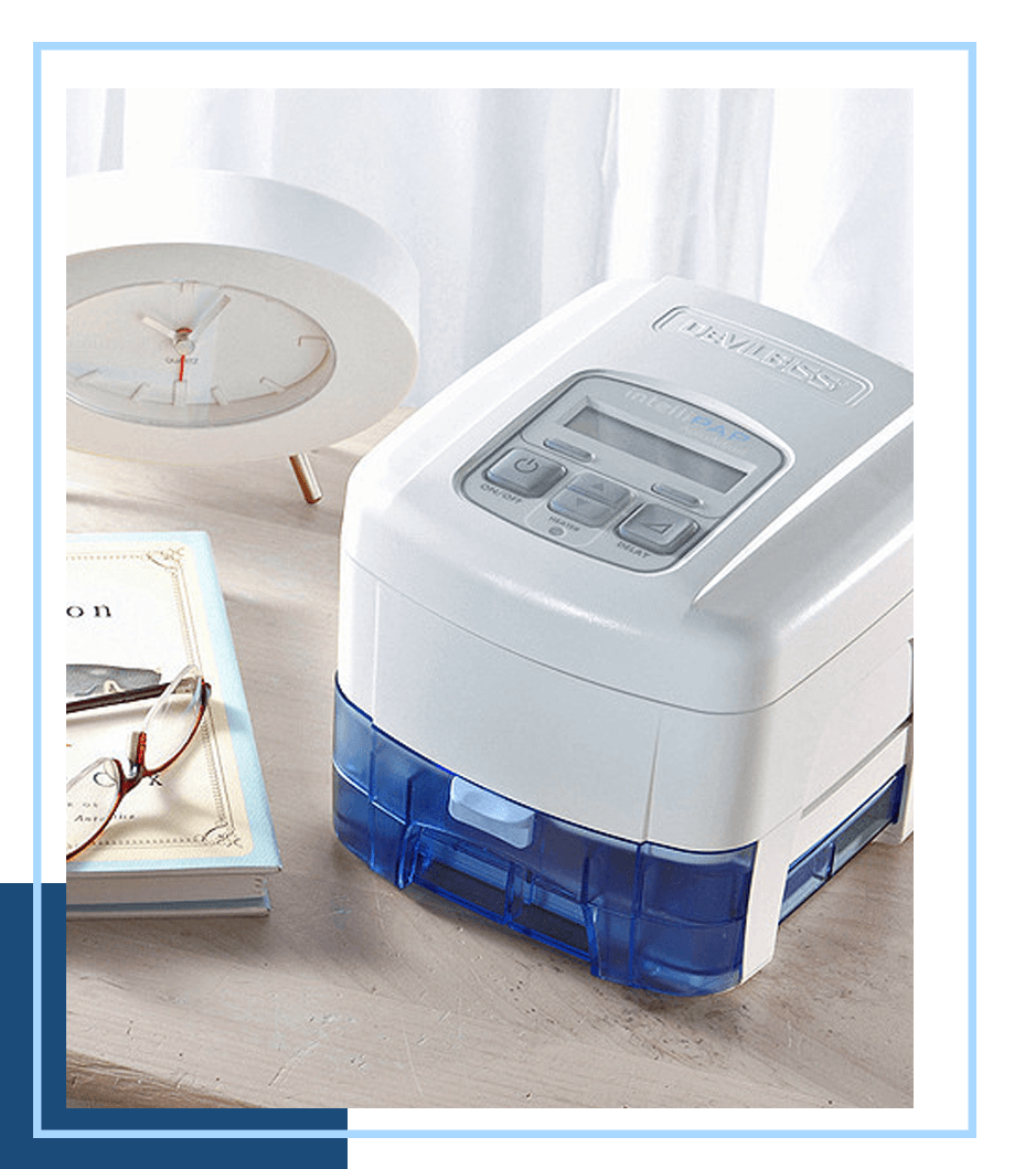 A BiPAP machine on a bedside table