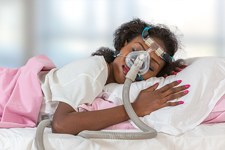 Woman wearing CPAP headgear mask for sleeping