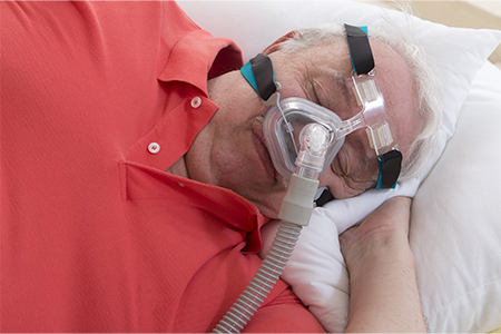 Senior Man with sleeping apnea and CPAP machine