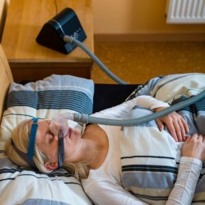 person sleeping with CPAP breathing machine