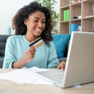 person holding credit card looking at computer