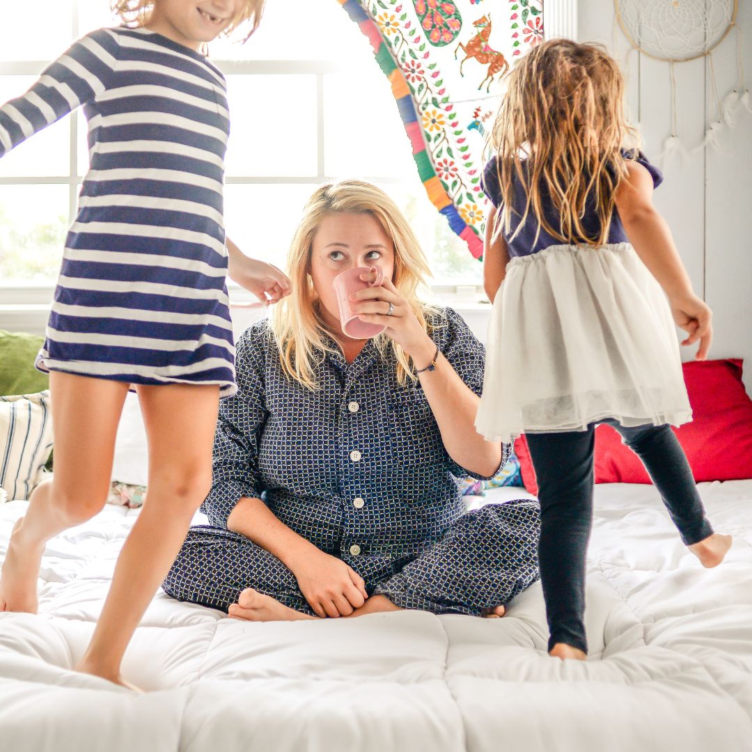 woman drinking coffee near her energetic kids
