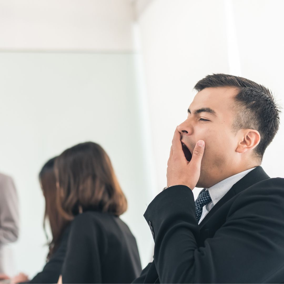 man yawning during business meeting