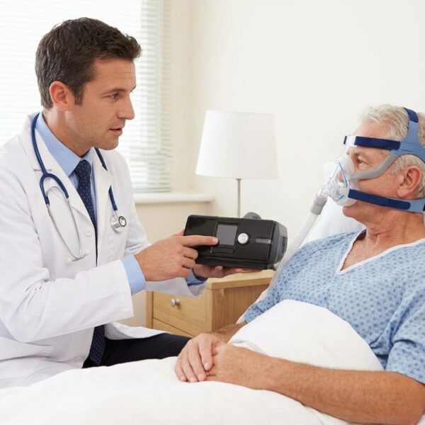 A healthcare professional demonstrates the proper setup and use of a BiPAP machine to a patient.